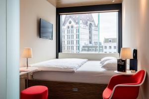 a hotel room with a bed, chair and window at citizenM Rotterdam in Rotterdam