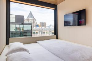 a bedroom with a bed and a large window at citizenM Rotterdam in Rotterdam
