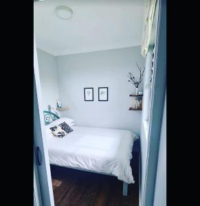 a small bedroom with a bed in a small room at Casetta del Fuoco - Eco Container Cottage in Plettenberg Bay