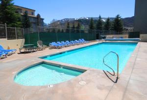 a large swimming pool with blue lounge chairs at Beaver Creek West 14 in Avon