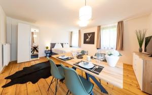Suiten am Rosenberg في غراتس: غرفة معيشة مع طاولة طعام وكراسي