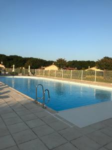 a swimming pool with a metal railing next to it at French country home III in Les Forges