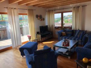 una sala de estar con sofás azules y una mesa. en Haus Leenja en Beverungen