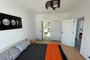 a bedroom with a bed with an orange blanket at Spacious Villa. Large Rooftop. 4 Bedroom Sleeps 8 in Alvor