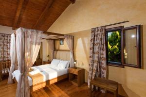 um quarto com uma cama e uma janela em Cretan Exclusive Villas em Agia Triada