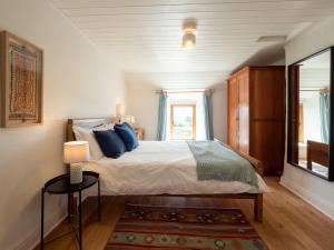 Un dormitorio con una cama con almohadas azules y una ventana en Wayside Cottage 1637 en Millom