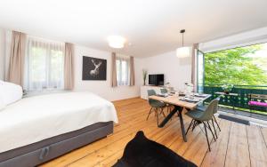 Suiten am Rosenberg في غراتس: غرفة نوم بسرير وطاولة مع كراسي