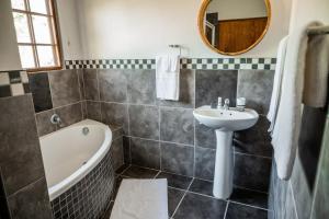 ein Badezimmer mit Waschbecken und Badewanne und Waschbecken in der Unterkunft Duiker Game Lodge in Hluhluwe