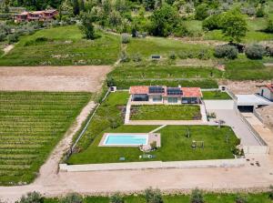 eine Luftansicht auf einen großen Garten mit Pool in der Unterkunft Villa Brusadela Suites Garda in Garda