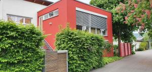 a red house with bushes in front of it at SEVIS Outlet Apartments in Metzingen