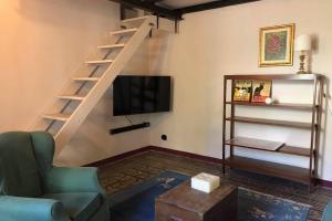 Una sala de estar con escalera y televisor. en Casina Marina, en Marina di Pisa