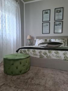 a bed with a green ottoman in a bedroom at Sofia's Cottage in Sommacampagna