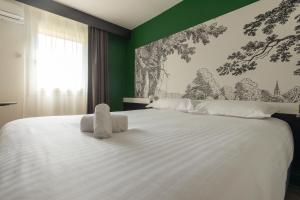 格拉迪尼昂The Originals City Hôtel Bordeaux Porte du Bassin的卧室里有一张白色的大床，墙壁是绿色的