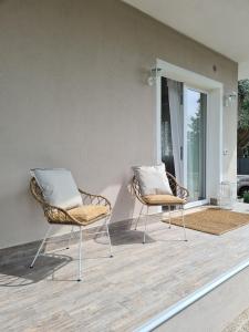 dwa krzesła siedzące na patio z oknem w obiekcie Sofia's Cottage w mieście Sommacampagna