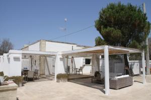 a white pergola on a patio in front of a house at Pittinta - il tuo rifugio a Vignacastrisi in Vignacastrisi
