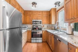 Una cocina con gabinetes de madera y un refrigerador de acero inoxidable. en River Park 1241, en Ouray