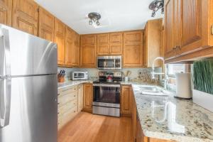 a kitchen with wooden cabinets and a stainless steel refrigerator at River Park 1241 in Ouray +21 photos
