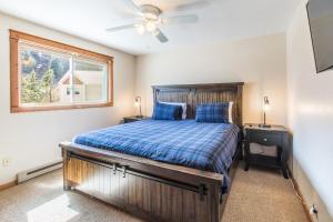 1 dormitorio con cama de madera y ventana en River Park 1241, en Ouray