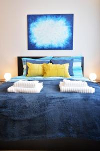 a blue bed with two pillows on top of it at NETTA APARTMAN in Eger