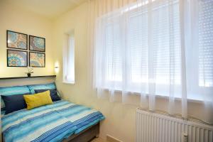 Schlafzimmer mit einem Bett und einem Fenster mit weißen Jalousien in der Unterkunft NETTA APARTMAN in Eger