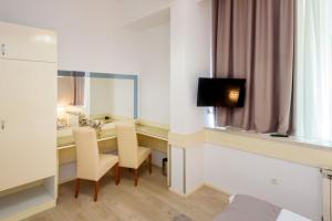 a room with a desk with chairs and a television at Hotel MB in Metković