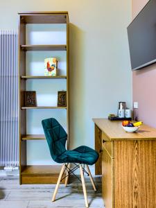 a green chair sitting next to a wooden desk at GRONO Apartamenty in Częstochowa