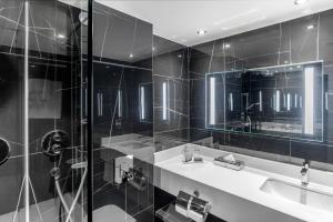 a bathroom with two sinks and a glass shower at Sofitel London Gatwick in Horley