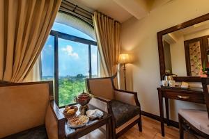 Zimmer mit einem Tisch und Stühlen sowie einem großen Fenster in der Unterkunft Envoy Continental Hotel in Islamabad