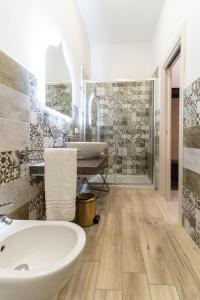 Un baño con bañera blanca y lavabo. en Biù b&b, en Castellammare di Stabia