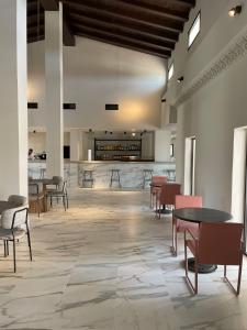 a lobby with tables and chairs and a bar at Hacienda Soto-Hego Haizea in Chiclana de la Frontera