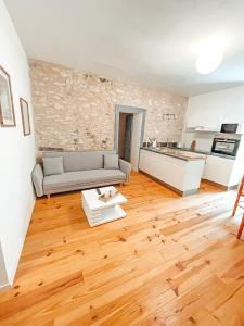 sala de estar con sofá y suelo de madera en Bel appartement T3 avec terrasse, en Carmaux