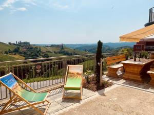 a couple of chairs and a painting on a patio at Apartment Weingartenblick - Glanzerhof in Gamlitz