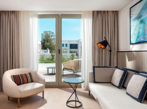a living room with a couch and a chair at Radisson Collection Hotel, Bodrum in Akyarlar