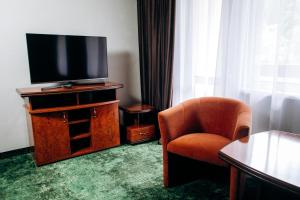 a hotel room with a television and a chair at Stanislavsky Hotel Group in Yaremche