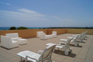 a row of white chairs and tables on a roof at Alberg Los Josepets in Les Cases d'Alcanar