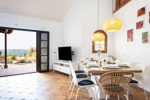 jadalnia ze stołem, krzesłami i telewizorem w obiekcie Casa Platano - Private pool - Ocean View - BBQ - Garden - Terrace - Free Wifi - Child & Pet-Friendly - 4 bedrooms - 8 people w mieście Poris de Abona