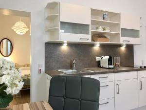 a kitchen with white cabinets and a sink at Die Trauminsel 2 in Lindau