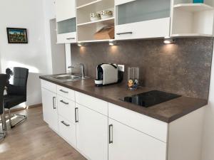 uma cozinha com armários brancos e um lavatório em Die Trauminsel 2 em Lindau