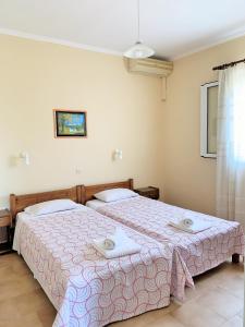 two beds sitting next to each other in a bedroom at Dionysios Studios in Skala