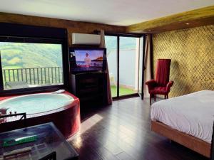 a bedroom with a tub with a television and a bed at LA ALDEA SOÑADA in Oviedo