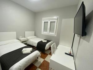 Kleines Zimmer mit 2 Betten und einem Flachbild-TV. in der Unterkunft FONDA CHIQUITO in Alhama de Almería