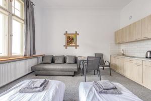 um quarto com duas camas, uma mesa e um sofá em Stara Piekarnia - Pułaskiego 3 em Olsztyn