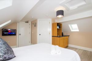 1 dormitorio con 1 cama blanca y TV en Quay 8, en Derry Londonderry