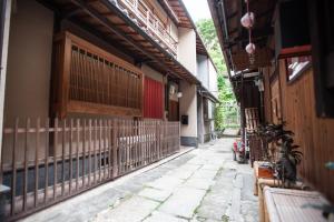 an alley with a fence in front of a building at Kiyomizu Machiya Inn in Kyoto