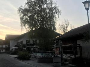un edificio con un árbol delante de él en Homerhof - Hofmann Johann junior, en Rottau