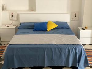 1 dormitorio con cama azul y almohada amarilla en Case Vacanze Giovanna, en Petrosino