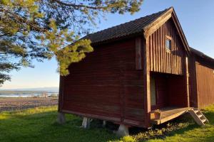 un pequeño cobertizo de madera sentado en la parte superior de un campo en Mysigt härbre med fantastisk utsikt!, en Östersund