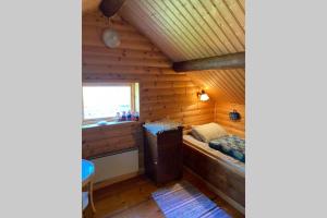Habitación con cama en una cabaña de madera en Mysigt härbre med fantastisk utsikt!, en Östersund