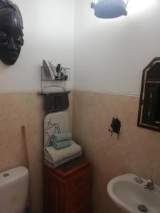 a bathroom with a sink and a mask on the wall at Casa Privada do Plateau in Praia