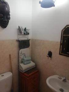 een badkamer met een wastafel en een masker op de muur bij Casa Privada do Plateau in Praia